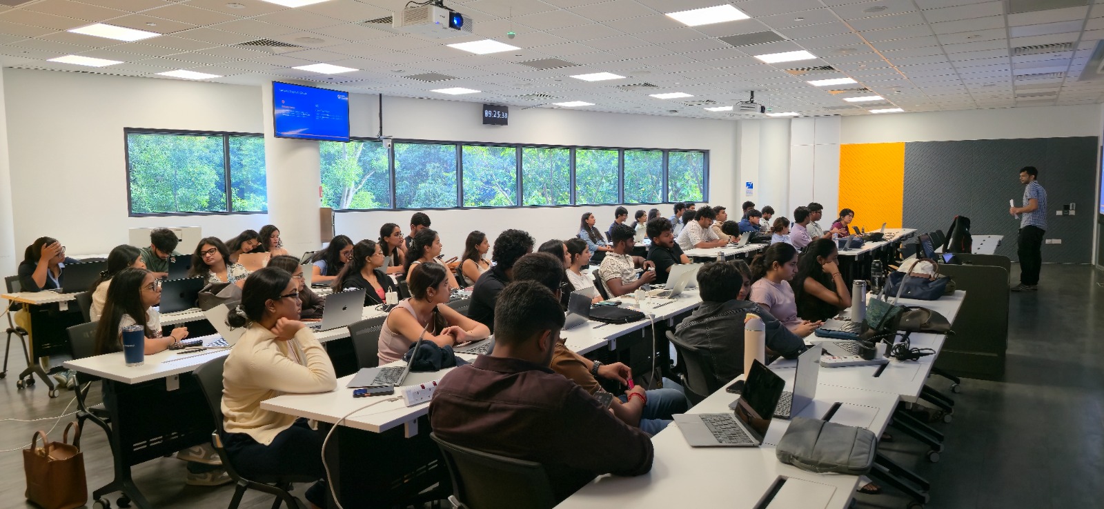 Students participating in a classroom session at a Singapore university, working on laptops in a modern learning environment